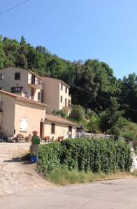 una casa con un seto delante de un edificio en Gîtes à COZZANO, en Cozzano