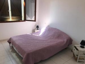 a bedroom with a bed with a purple blanket on it at Gîtes à COZZANO in Cozzano