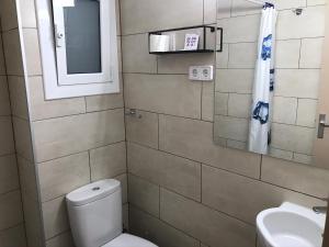 a bathroom with a toilet and a sink and a mirror at Hostal Radio Barcelona in Barcelona