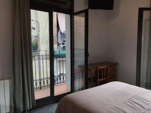 a bedroom with a bed and a view of a balcony at Hostal Radio Barcelona in Barcelona