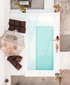 an overhead view of a woman in a pool with an umbrella at Playa del Mar - Adults Only in Monopoli