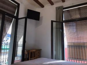 a bedroom with a bed and two large windows at Hostal Radio Barcelona in Barcelona