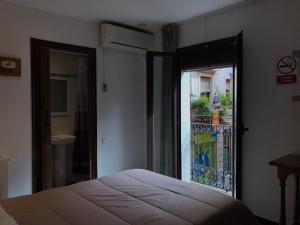 a bedroom with a bed and a window with a balcony at Hostal Radio Barcelona in Barcelona