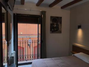 a bedroom with a bed and a view of a balcony at Hostal Radio Barcelona in Barcelona