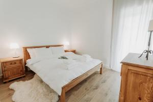 um quarto com uma cama grande e lençóis brancos em Apartament JODEŁKA em Szczyrk