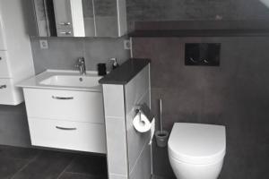 La salle de bains est pourvue de toilettes blanches et d'un lavabo. dans l'établissement Ferienwohnung Weserblick, à Hessisch Oldendorf