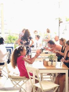 un grupo de personas sentadas en mesas en un restaurante en Dream House, en Tsarevo