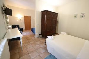 a bedroom with a bed and a desk and a sink at casadiviaappia in Imola
