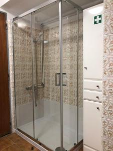 a shower with a glass door in a bathroom at Sabor a Verão, T1 em frente à praia com TV in Figueira da Foz