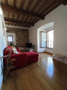 een woonkamer met een rode bank en een bakstenen muur bij Mazzini 3 in Assisi