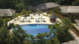een luchtzicht op een zwembad van het resort met stoelen en parasols bij Hotel Villa Mercedes Palenque in Palenque