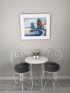 Seaforth Suite في سيمونز تاون: طاولة وكرسيين مع صورة على الحائط