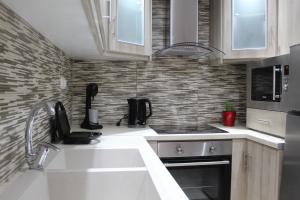 a kitchen with a sink and a stove at VAKIS APARTMENTS 5 in Romanón