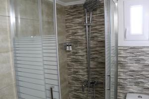 a shower with a glass door in a bathroom at VAKIS APARTMENTS 5 in Romanón +15 photos