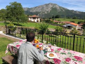 a man sitting at a table with a plate of food at Villa Marta Casa de Indianos Passive House in Villanueva de Ardisana +29 photos