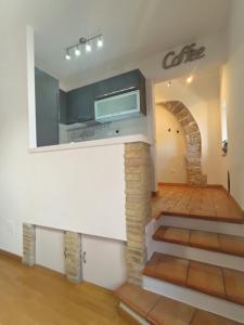 una sala de estar con escaleras y un arco en Mazzini 3, en Asís