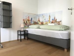 a bedroom with a large bed with a painting on the wall at Townus Apartments Wiesbaden in Wiesbaden