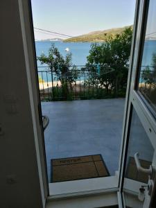 - une porte donnant sur un balcon avec vue sur l'océan dans l'établissement Apartmani Skalinada, à Marina