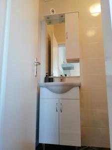 La salle de bains est pourvue d'un lavabo et d'un miroir. dans l'établissement Apartmani Skalinada, à Marina