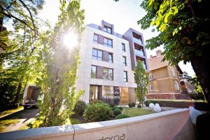 Un grand bâtiment blanc avec le soleil brillant sur lui dans l'établissement Grand Apartments - Prestigious Apartment Sopot Victoria Residence, à Sopot