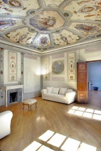 a living room with a ceiling with paintings on it at Palazzo Tolomei - Residenza D'Epoca in Florence