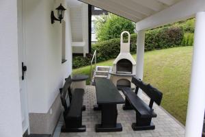 a patio with benches and a grill on a house at Ferienhaus am Ruhberg in Winterberg