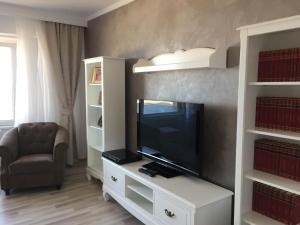 een woonkamer met een televisie op een wit entertainmentcentrum bij Apartament Plaja Golful Pescarilor in Constanţa