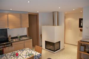 a kitchen with a living room with a fireplace at Castello in Saas-Fee