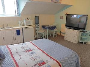 a bedroom with a bed and a kitchen with a sink at Cumbria Guest House in Lytham St Annes