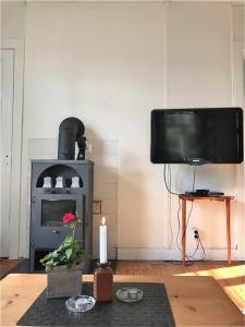 a living room with a fireplace and a television at Holsby banvaktarstuga in Ransäter