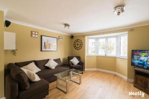 a living room with a couch and a tv at Swan Place - Comfortable Home in Reading