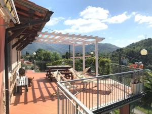 a deck with a picnic table and a view of the mountains at Baita Chalet del Colle in Corsanico-Bargecchia