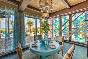 een eetkamer met een tafel en een kroonluchter bij Luxe Beachfront Villa with Indoor Pool and Gulf View in Englewood
