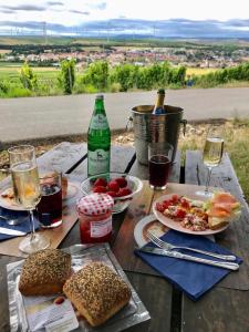 - une table avec des assiettes de nourriture et des verres de vin dans l'établissement Ferienwohnung Natali, à Gau-Bickelheim