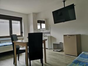 um quarto com uma mesa e uma televisão na parede em Gemütliches Ferienzimmer Hürth em Hürth