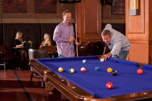 two men playing a game of pool in a bar at Omni Fort Worth Hotel in Fort Worth