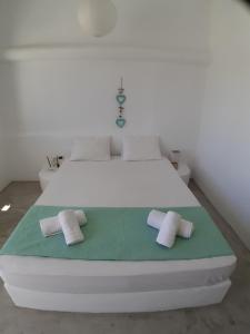 ein Schlafzimmer mit einem weißen Bett mit zwei Kissen darauf in der Unterkunft Thea Serifos in Livadakia