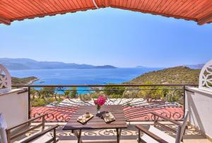 a balcony with a table and a view of the ocean at Hamarat Otel in Kaş