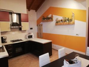 a kitchen with orange and white walls and a table at Casa Vacanze Gaia in Cividale del Friuli
