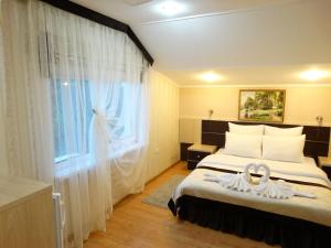 Habitación de hotel con cama y ventana en Atriy Hotel, en Simeiz