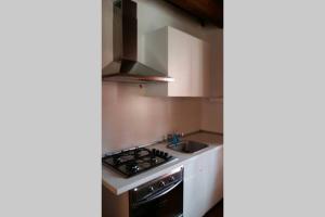 a kitchen with a stove and a sink at Il Duomo 2 in Osimo