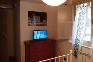 a television sitting on top of a dresser with a window at Il Duomo 2 in Osimo