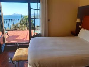 a bedroom with a bed and a view of the ocean at Hotel Rústico Punta Uia in Uhía +32 photos