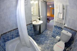 a bathroom with a toilet and a sink and a tub at Приятелската къща in Velingrad