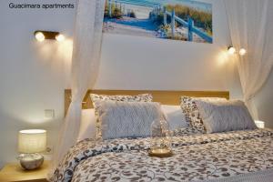 ラ・プラヤ・デ・アルグイネグインにあるGuacimara Apartmentsのベッドルーム1室(枕付きのベッド1台、絵画付) +52枚の写真