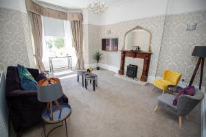 a living room with a couch and a fireplace at Lynwood House in Southport