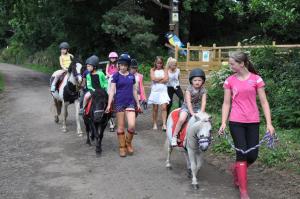 een groep kinderen die paardrijden op een pad bij Wellsfield Farm Holiday Lodges in Stirling