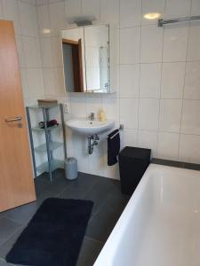 a bathroom with a white tub and a sink at Katjas Ferienwohnung in Nittel