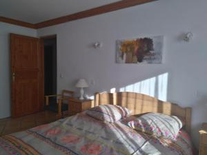 ein Schlafzimmer mit einem Bett mit einem Kopfteil aus Holz in der Unterkunft L'Embrune in Tignes