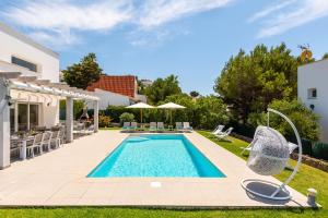 a swimming pool in the backyard of a house at Villa Galerna in Son Bou